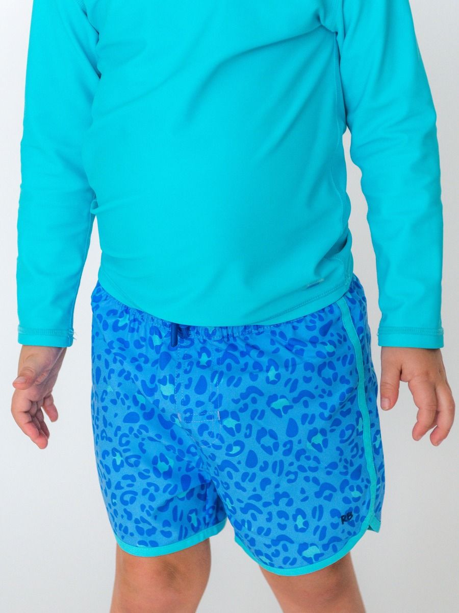 RuffleButts| Blue Leopard Dolphin Hem Swim Trunks